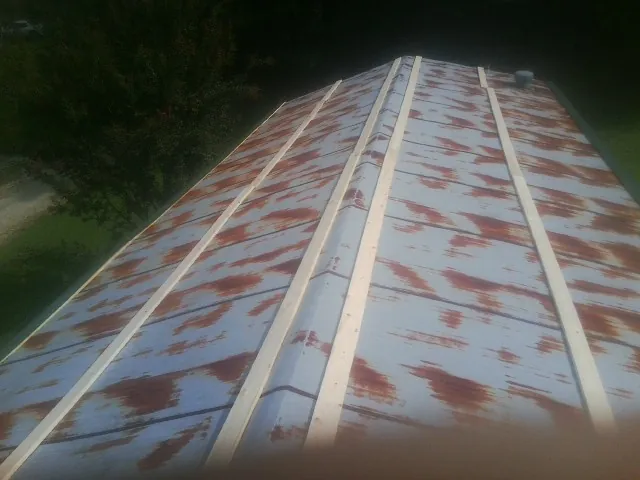 Rusted metal roof panels with new wood purlins before replacement — Storm Damage Roof Repair in Lostant by Roofing Brothers